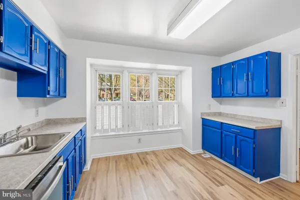 a kitchen with granite countertop wooden cabinets a sink and dishwasher