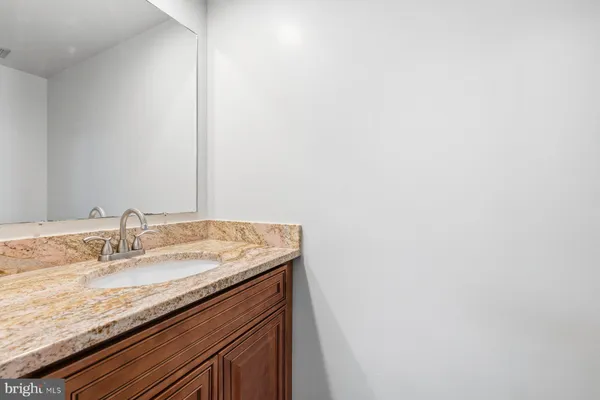 a bathroom with a granite countertop sink and a mirror