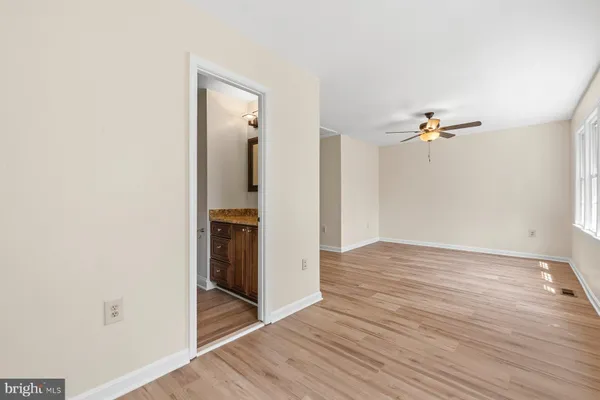a view of a livingroom with wooden floor and a ceiling fan
