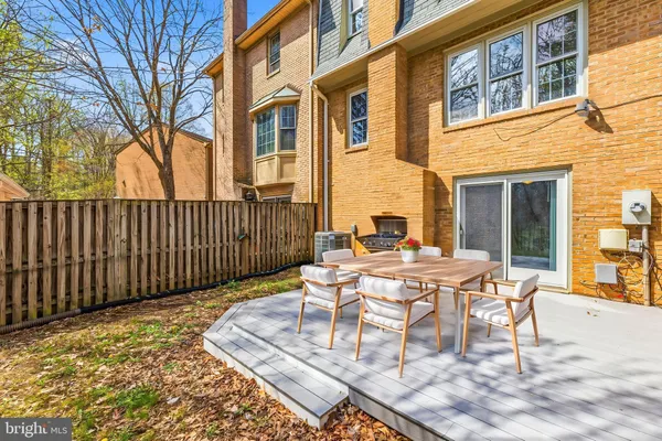 a view of a patio with a table and chairs and wooden fence
