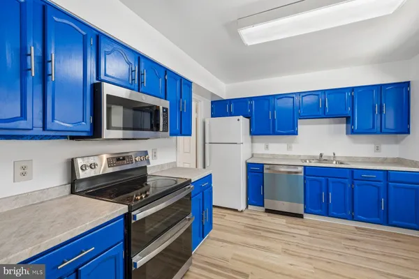 a kitchen with stainless steel appliances granite countertop wooden cabinets sink stove and refrigerator