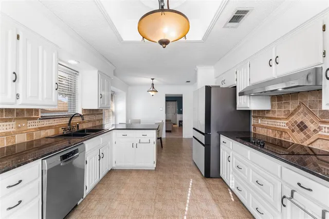 a kitchen with granite countertop a sink stainless steel appliances and cabinets