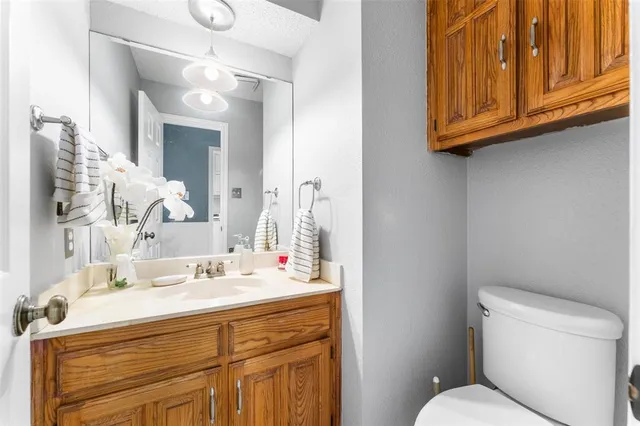 a bathroom with a sink vanity mirror and toilet