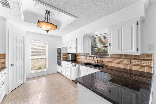 a kitchen with stainless steel appliances granite countertop a sink a stove and cabinets