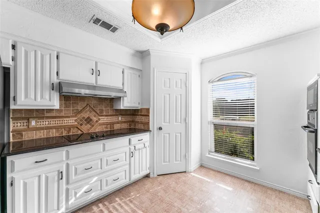 a kitchen with granite countertop a white cabinets and a dishwasher