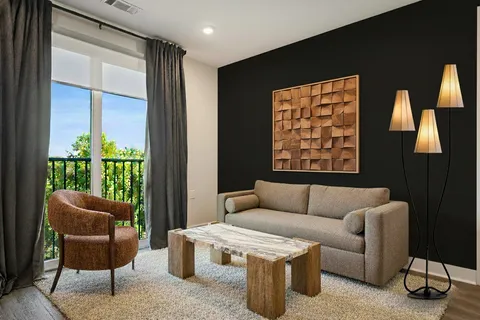 a living room with furniture a floor to ceiling window and a flat screen tv