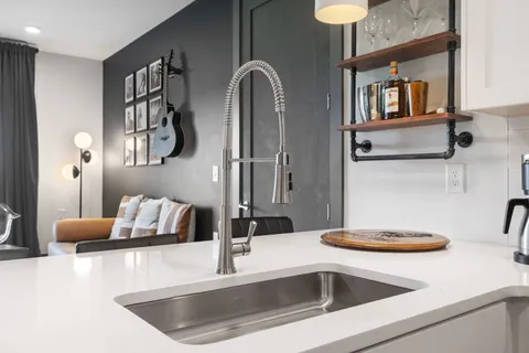 a kitchen with stainless steel appliances kitchen island granite countertop a refrigerator a stove and a sink