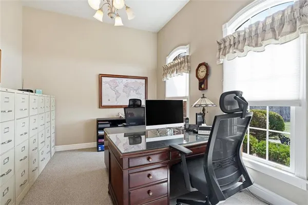 a view of a workspace with furniture and a window