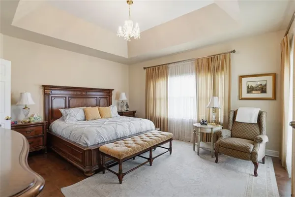 a bedroom with a bed couch and windows