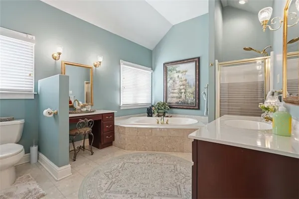 a spacious bathroom with a tub sink and mirror