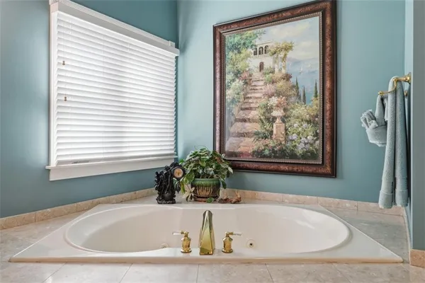 a white bath tub sitting in a bathroom next to a window