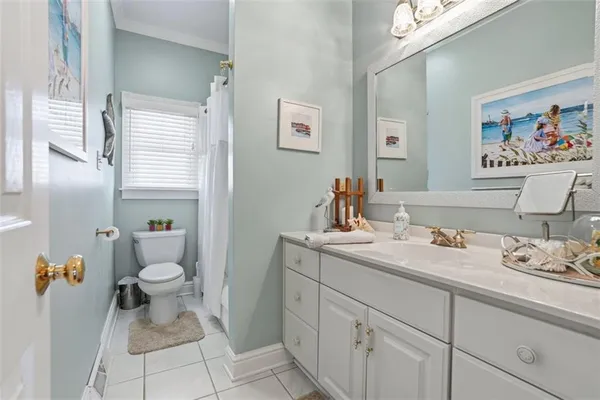 a bathroom with a granite countertop toilet sink and mirror
