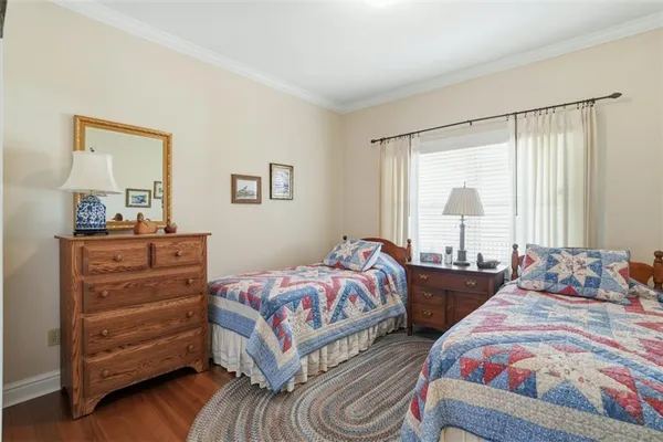 a bedroom with two beds and large windows