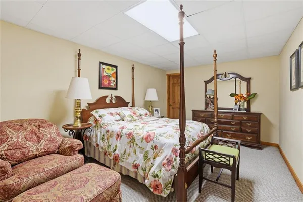 a bedroom with bed a couch and a chandelier