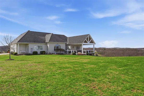 a aerial view of a house next to a big yard with large trees