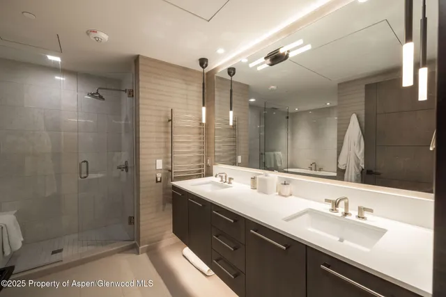 a bathroom with a double vanity sink mirror and shower