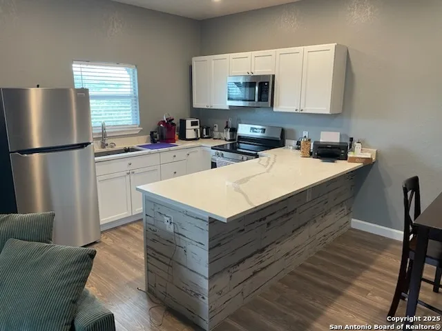 a kitchen with granite countertop a sink and a refrigerator