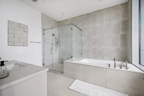a bathroom with a tub a sink and mirror