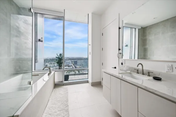 a large bathroom with a double vanity sink a mirror and a bathtub