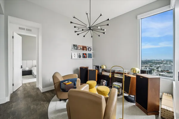 a living room with furniture a chandelier and a view of kitchen