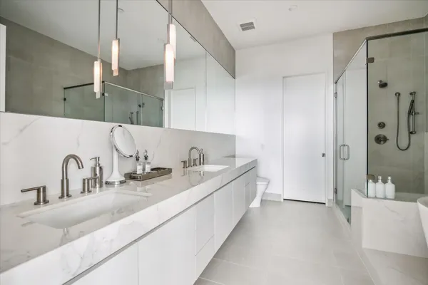 a bathroom with a double vanity sink a mirror and a bathtub