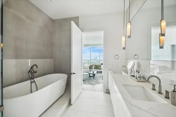 a bathroom with a tub sink and mirror