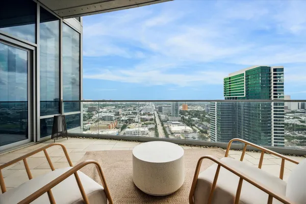 a view of a balcony with chair and a floor to ceiling window