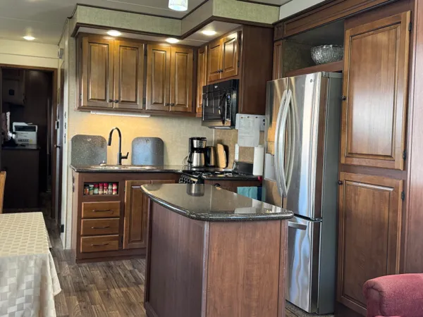 a metallic refrigerator and stove sitting inside of a kitchen