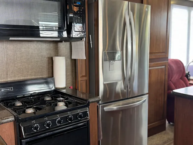 a kitchen with stainless steel appliances granite countertop a refrigerator and a sink