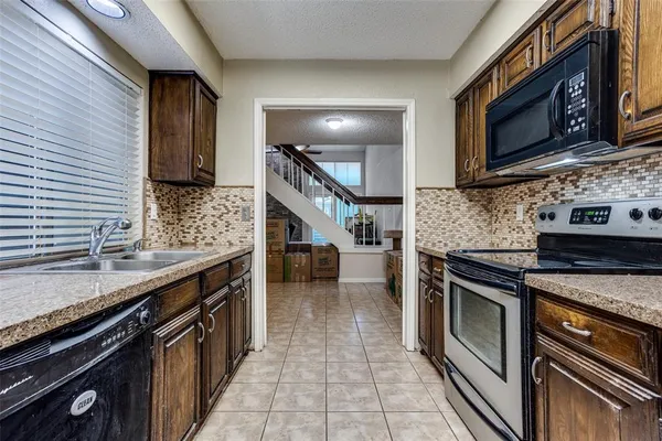 a kitchen with stainless steel appliances granite countertop a stove a sink and a microwave