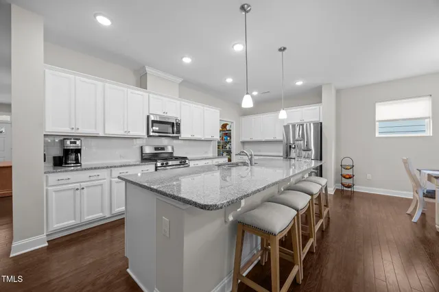 a living room with furniture kitchen and a table