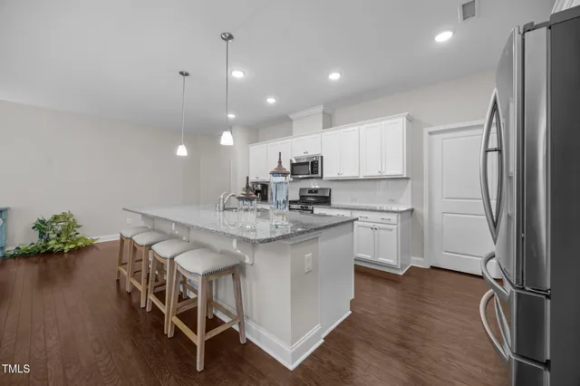 a kitchen with stainless steel appliances granite countertop a lot of counter space and wooden floors