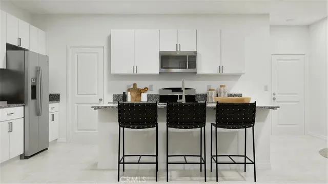 a kitchen with stainless steel appliances a stove a sink a microwave and cabinets