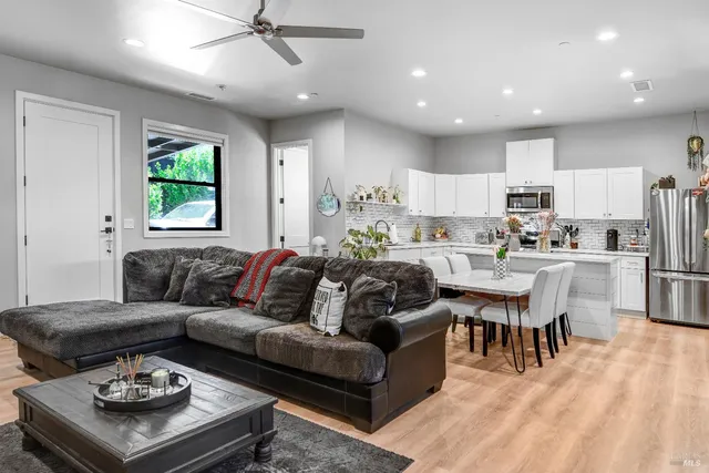a room with lots of chairs a chandelier and a large window