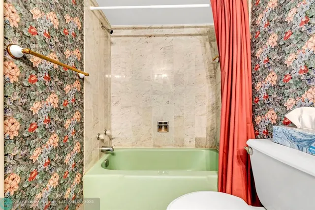 a white toilet sitting next to a shower curtain