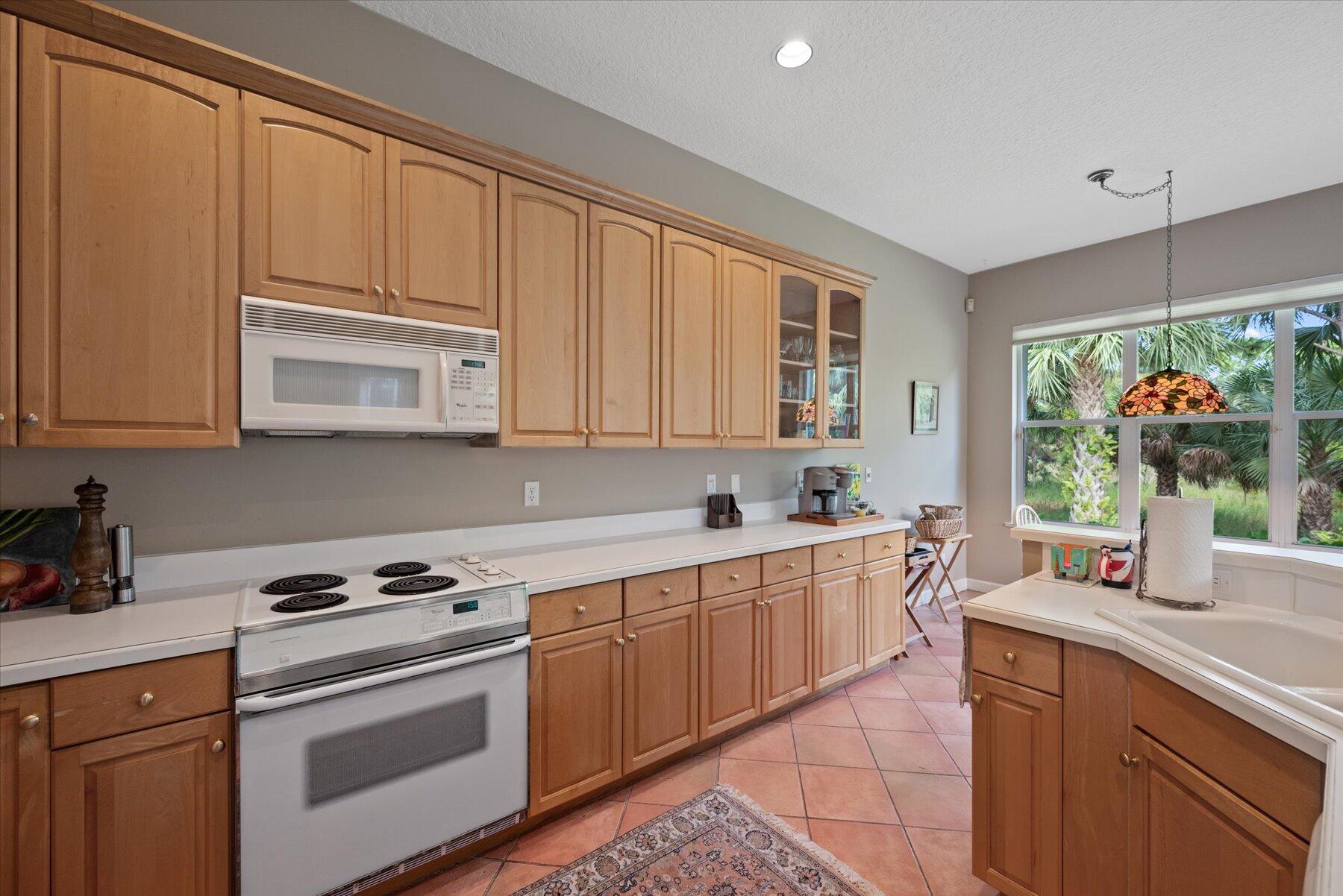 3498 Southeast Doubleton Drive Stuart, FL 34997 - Photo 11 of 42 a kitchen with stainless steel appliances granite countertop a stove a sink and a microwave