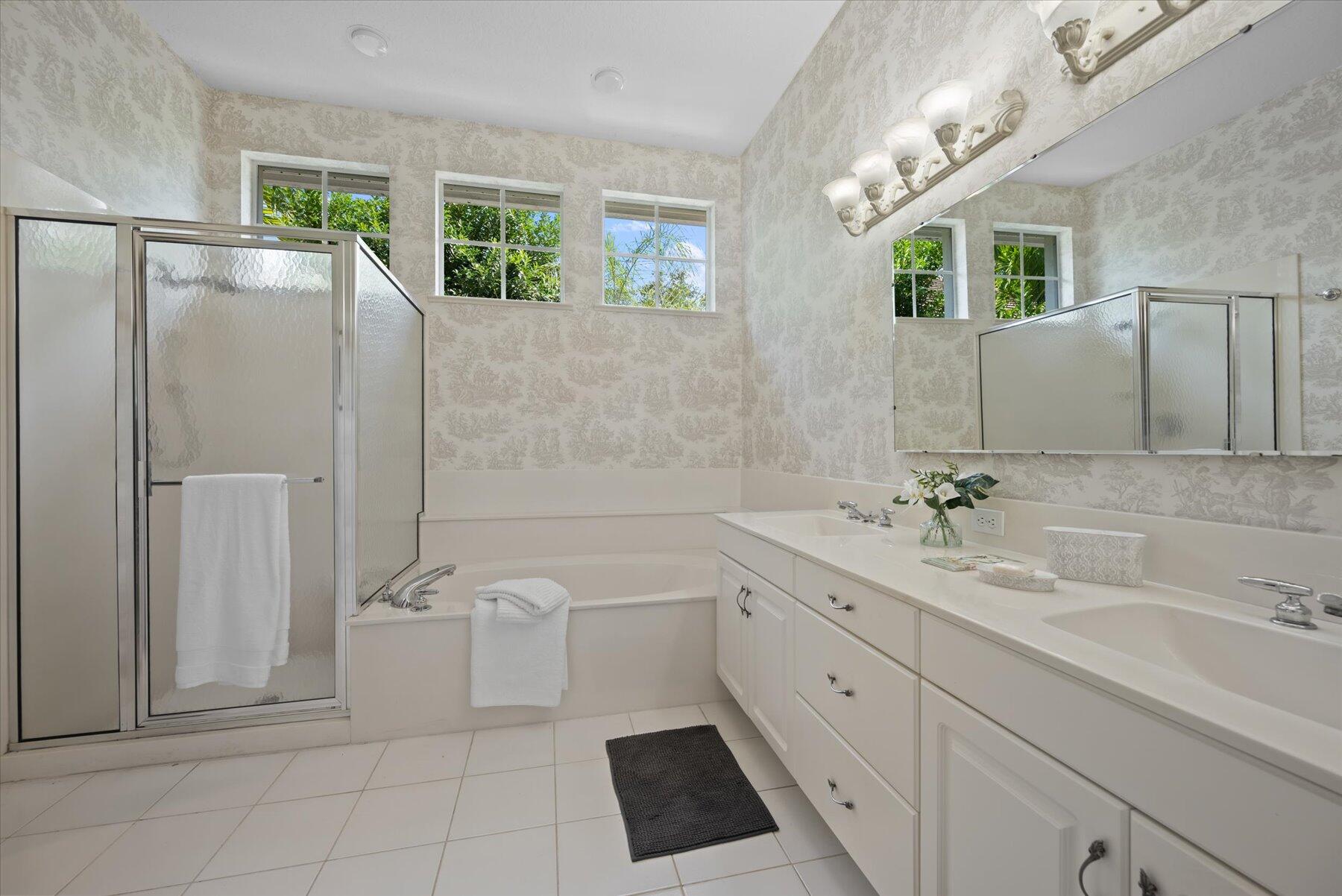 3498 Southeast Doubleton Drive Stuart, FL 34997 - Photo 19 of 42 a spacious bathroom with a double vanity sink a mirror and a bathtub