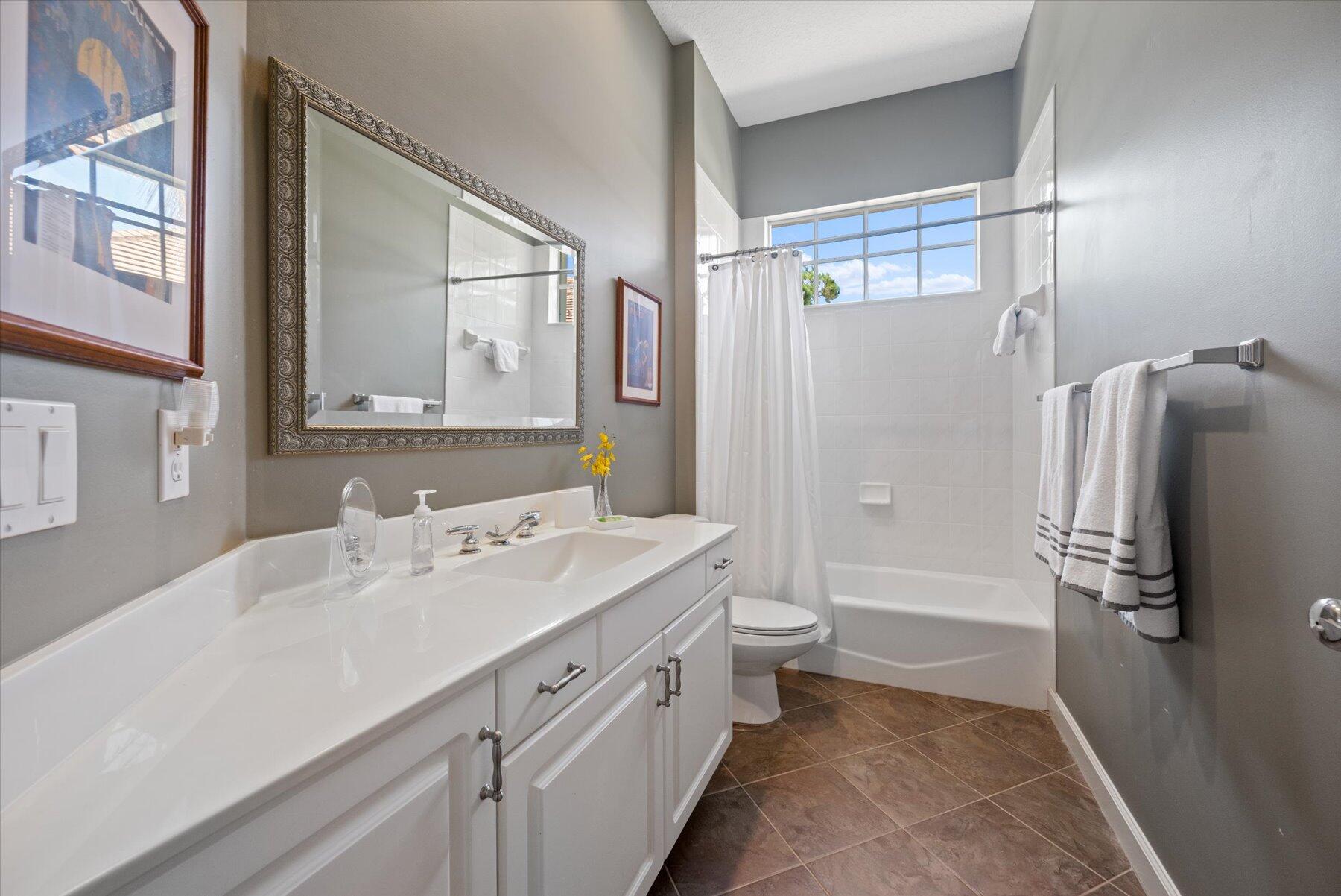 3498 Southeast Doubleton Drive Stuart, FL 34997 - Photo 23 of 42 a bathroom with a double vanity sink toilet mirror and bathtub