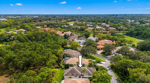 an aerial view of residential houses with outdoor space and trees