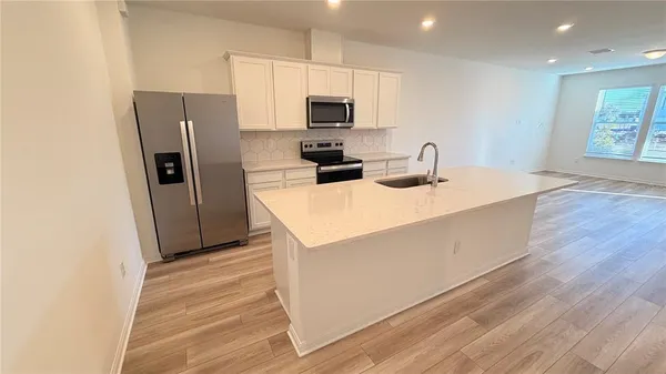 a kitchen with refrigerator cabinets and wooden floor