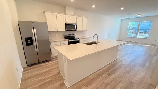 a kitchen with stainless steel appliances a refrigerator a stove a microwave and island