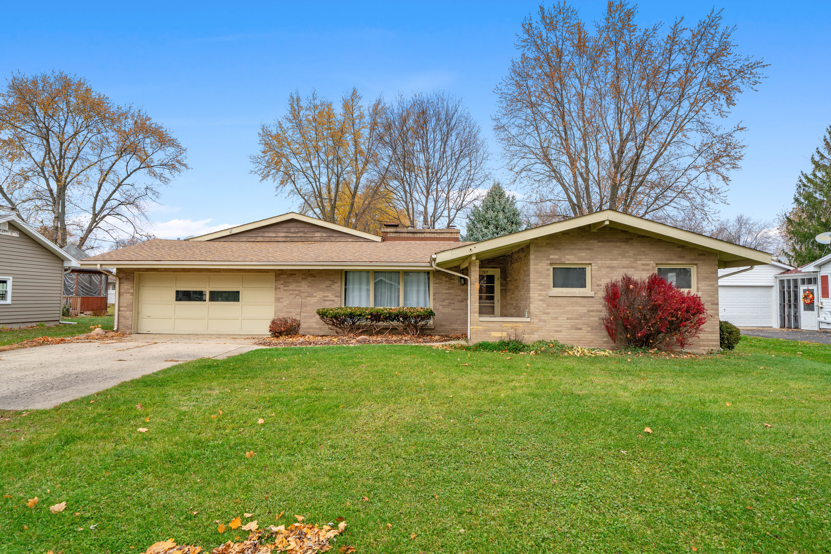 a front view of a house with a garden and trees