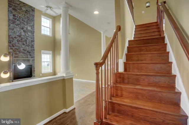 a kitchen with stainless steel appliances granite countertop a refrigerator a sink a stove and a wooden floors