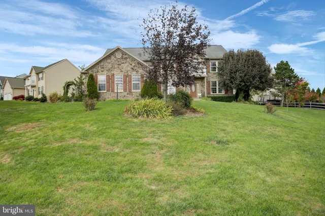 a view of a house with a big yard and large trees