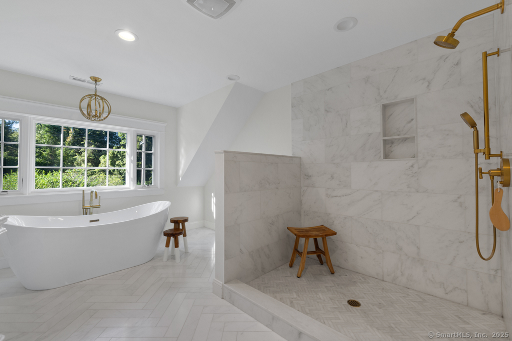 93 East Meadow Road Wilton, CT 06897 - Photo 22 of 35 a bathroom with a tub a window and a shower