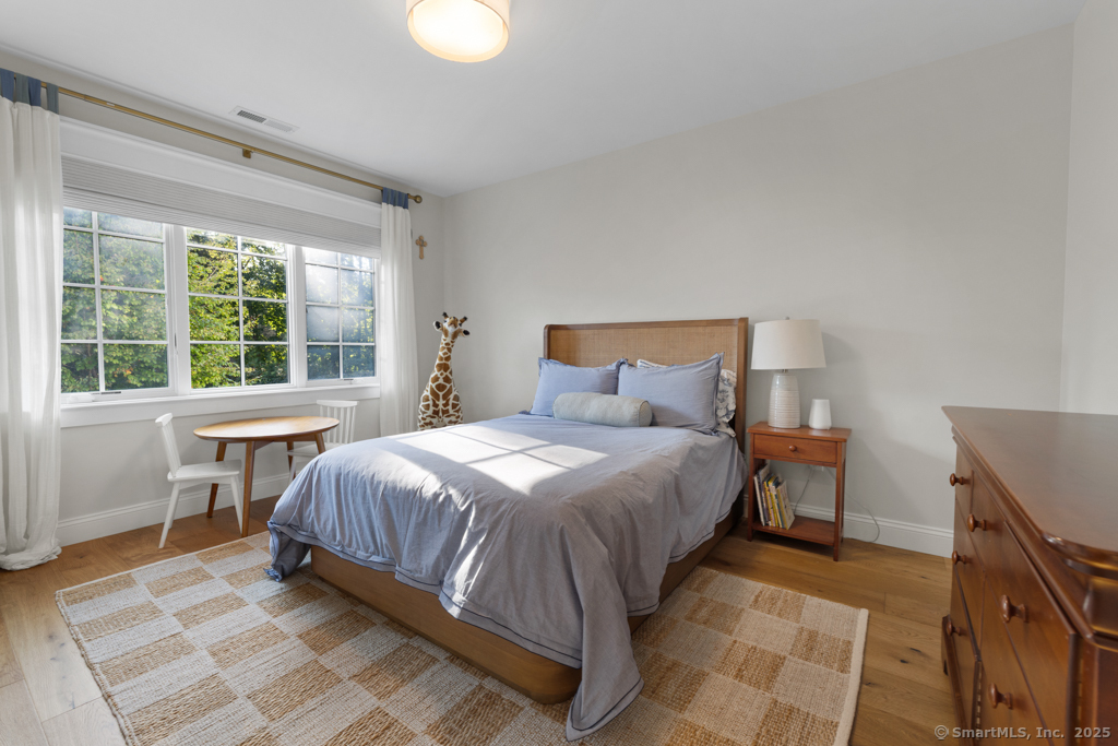 93 East Meadow Road Wilton, CT 06897 - Photo 25 of 35 a bedroom with a bed and wooden floor