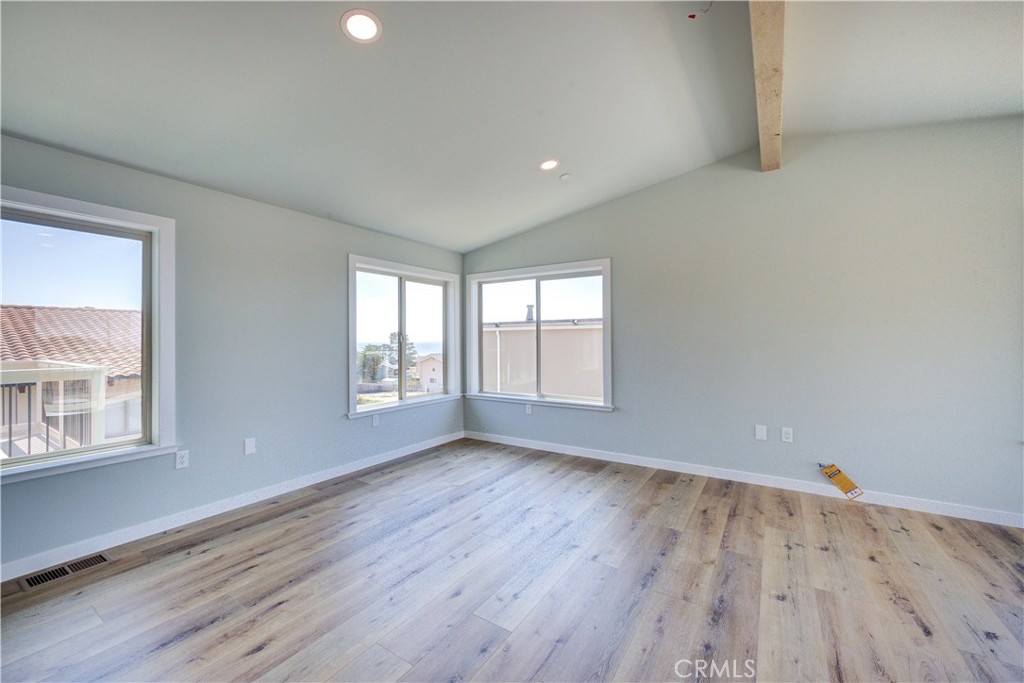 396 Castle Street Cambria, CA 93428 - Photo 18 of 74 an empty room with wooden floor and windows