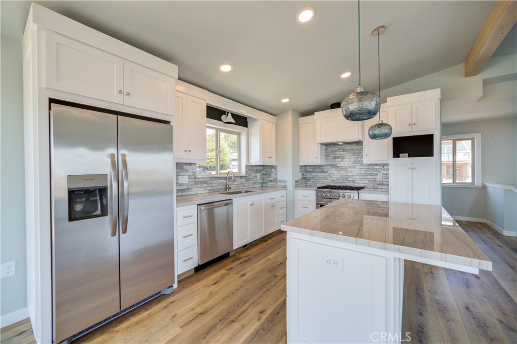 396 Castle Street Cambria, CA 93428 - Photo 26 of 74 a kitchen with a refrigerator a sink and cabinets