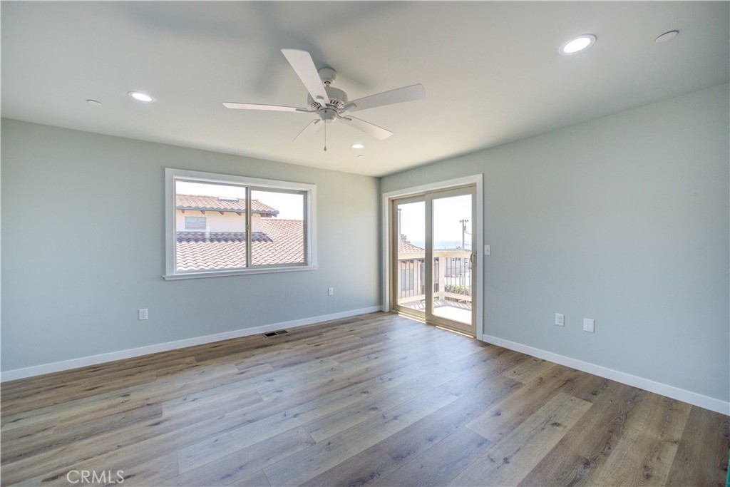 396 Castle Street Cambria, CA 93428 - Photo 28 of 74 an empty room with wooden floor fan and windows
