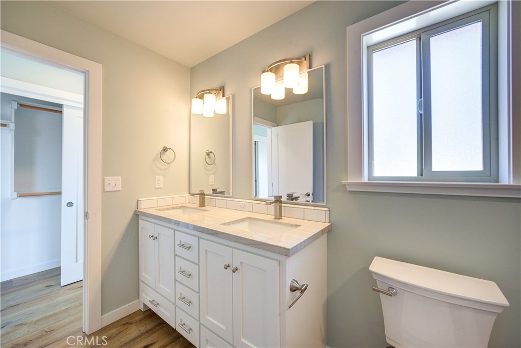 396 Castle Street Cambria, CA 93428 - Photo 34 of 74 a bathroom with a granite countertop sink toilet a large mirror and a window